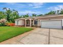Charming single story home with a lush green lawn and an attached two car garage at 10305 Worthy Lamb Way, New Port Richey, FL 34654