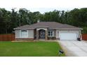 Charming single-story house with a manicured lawn, attached garage, and inviting front entrance at 10305 Worthy Lamb Way, New Port Richey, FL 34654
