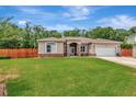 Charming single story home with a lush green lawn and an attached two car garage at 10305 Worthy Lamb Way, New Port Richey, FL 34654