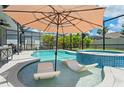 Relaxing screened-in pool area with in-pool loungers and a covered patio for outdoor dining at 11742 Lake Lucaya Dr, Riverview, FL 33579