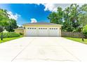 Detached three-car garage with a long driveway, well-kept lawn and good lighting at 12435 Oak St, San Antonio, FL 33576