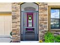 Close-up of the front door entrance framed with stone, showcasing a wreath, and a glimpse of the interior at 12643 Horseshoe Bend Dr, Lithia, FL 33547