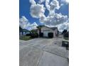 Spacious driveway leading to a single-story home with an attached garage and fenced yard with lawn at 1332 Fuchsia Dr, Holiday, FL 34691