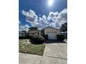 Well-maintained single-story home with a clean driveway, attached garage and neatly trimmed hedges in front at 1332 Fuchsia Dr, Holiday, FL 34691