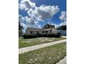 Single-story home with a tidy yard, attached garage, and mature landscaping, presenting a cozy curb appeal at 1332 Fuchsia Dr, Holiday, FL 34691