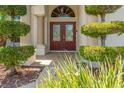 Inviting front entryway featuring double doors with decorative glass and neatly trimmed shrubs on either side at 13375 Newcastle Ave, Spring Hill, FL 34609