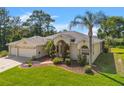 Attractive one-story home with a three-car garage, lush landscaping, and a well-manicured lawn at 13375 Newcastle Ave, Spring Hill, FL 34609