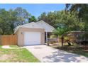 Inviting single-story home with a two-car garage, complemented by lush landscaping and a welcoming front porch at 1344 S Michigan Ave, Clearwater, FL 33756