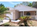 Close up shot of the exterior featuring a quaint front porch and neatly landscaped front yard with mature palms at 1344 S Michigan Ave, Clearwater, FL 33756