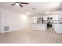 Open-concept living space with new wood flooring connecting to an updated kitchen with stainless steel appliances at 1344 S Michigan Ave, Clearwater, FL 33756