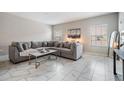Bright living room with large grey couch, marble floors and modern decor at 1543 W Cass St, Tampa, FL 33606