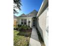 Front exterior with manicured lawn and lush landscaping and a lovely walkway to the door at 18108 Ashton Park Way, Tampa, FL 33647