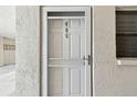 Image of unit 406 front door featuring a storm door and a window to the side at 200 1St Ave # 406, St Pete Beach, FL 33706