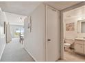 Hallway view of unit leading to living/dining area and a half bath at 200 1St Ave # 406, St Pete Beach, FL 33706