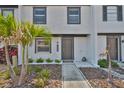 Charming townhome featuring a painted brick facade, complemented by tropical landscaping and inviting front entrance at 2011 S Carolina Ave, Tampa, FL 33629