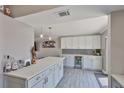 A modern kitchen features gray and white cabinets, tile backsplash and a sleek beverage refrigerator at 2011 S Carolina Ave, Tampa, FL 33629