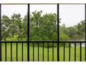 Enjoy serene views of lush greenery and a tranquil lake from the screened-in balcony at 210 Cypress Ct # 122, Oldsmar, FL 34677