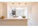 Bright kitchen with modern pendant lighting, quartz countertops, and stainless steel appliances at 210 Cypress Ct # 122, Oldsmar, FL 34677