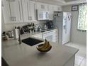 Bright kitchen featuring white cabinets, sleek countertops, and modern appliances at 210 Cypress Ct # 122, Oldsmar, FL 34677