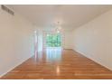 Spacious living room with gleaming hardwood floors and a glass sliding door leading to a balcony at 210 Cypress Ct # 122, Oldsmar, FL 34677