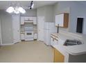 Bright kitchen featuring white appliances, ample cabinet space, and a double stainless steel sink at 24741 Ravello St, Land O Lakes, FL 34639
