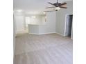 Spacious living room with neutral carpet, ceiling fan, and an open layout to the kitchen area at 24741 Ravello St, Land O Lakes, FL 34639