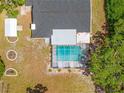 Aerial view of a backyard with a screened-in pool, patio area, and green landscaping at 3041 Waterfall Dr, Spring Hill, FL 34608
