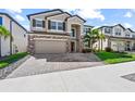 Attractive two-story house boasts a stone facade, well-kept lawn, and a spacious driveway at 3071 Marine Grass Dr, Wimauma, FL 33598