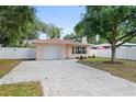 Inviting single-Gathering home with a paved driveway, showcasing its well-maintained lawn and charming facade at 3303 W Ballast Point Blvd, Tampa, FL 33611