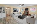 This spacious living room boasts a brick fireplace, ceiling fan, and wood-look flooring at 3303 W Ballast Point Blvd, Tampa, FL 33611