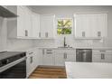 Bright kitchen boasts white cabinets, stainless steel appliances, and stylish finishes, creating a modern culinary space at 331 Archimedes St, Dunedin, FL 34698