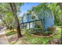 Two-story townhouse showcasing blue siding and lush greenery in a community setting at 3343 Fox Hunt Dr, Palm Harbor, FL 34683