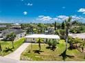 Charming single-story home featuring a well-maintained lawn, mature trees, and a classic driveway at 3420 Santa Clara Dr, Punta Gorda, FL 33983