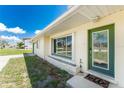 Inviting front entrance with a green door, decorative window, and a charming welcome mat at 3420 Santa Clara Dr, Punta Gorda, FL 33983