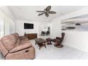Bright living room with tile floors, a ceiling fan, comfortable furniture, and a view to the dining area at 3420 Santa Clara Dr, Punta Gorda, FL 33983