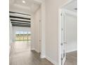 Hallway featuring wood-look flooring, decorative ceiling beams, and neutral-toned walls at 35280 Big Hawk Ln, Zephyrhills, FL 33541