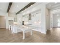 Bright kitchen with white cabinetry, stainless steel appliances, large island, and decorative wood beams at 35280 Big Hawk Ln, Zephyrhills, FL 33541