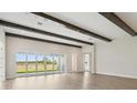 Spacious living room with expansive windows providing natural light and wood-look flooring at 35280 Big Hawk Ln, Zephyrhills, FL 33541