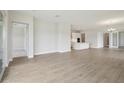 Spacious living room with light colored wood flooring, an open floor plan, and natural light at 35571 Stableton Ln, Zephyrhills, FL 33541