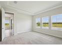 Bright main bedroom with tray ceiling and large windows overlooking the water at 35571 Stableton Ln, Zephyrhills, FL 33541