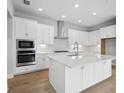 Bright kitchen with stainless steel appliances, white cabinets, and a center island at 35579 Stableton Ln, Zephyrhills, FL 33541