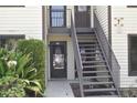 Two-story condo with cream siding, dark trim, outdoor stairways and green landscaping at 420 Moorings Cove Dr # 420, Tarpon Springs, FL 34689
