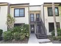 Two-story condo with cream siding, dark trim, outdoor stairways and green landscaping at 420 Moorings Cove Dr # 420, Tarpon Springs, FL 34689