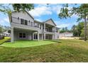 Back exterior of home with a two-story balcony, putting green, and spacious yard at 4522 Majestic Hills Loop, Brooksville, FL 34601