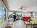 Bright sunroom with large windows, tiled floors, ceiling fan, and a comfortable seating area, perfect for relaxation at 4700 Cove Cir # 301, St Petersburg, FL 33708