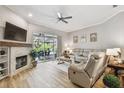 Comfortable living room featuring a fireplace, a ceiling fan, and sliding glass doors to the pool area at 5027 Cross Pointe Dr, Oldsmar, FL 34677