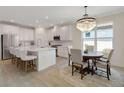 Open-concept kitchen with a large island, dining area with chandelier, and stainless steel appliances at 5410 Morey Farms Loop, Palmetto, FL 34221