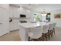 Bright white kitchen featuring a large island with seating, stainless steel appliances, and lots of cabinet space at 5410 Morey Farms Loop, Palmetto, FL 34221