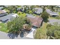 Aerial view of a home with a brown roof, attached two-car garage, driveway, and mature landscaping at 5507 Nimitz Rd, New Port Richey, FL 34652