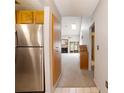 Bright hallway with stainless steel refrigerator and living room with fireplace and skylight beyond at 6201 Amaretto Ln # 6201, Tampa, FL 33634